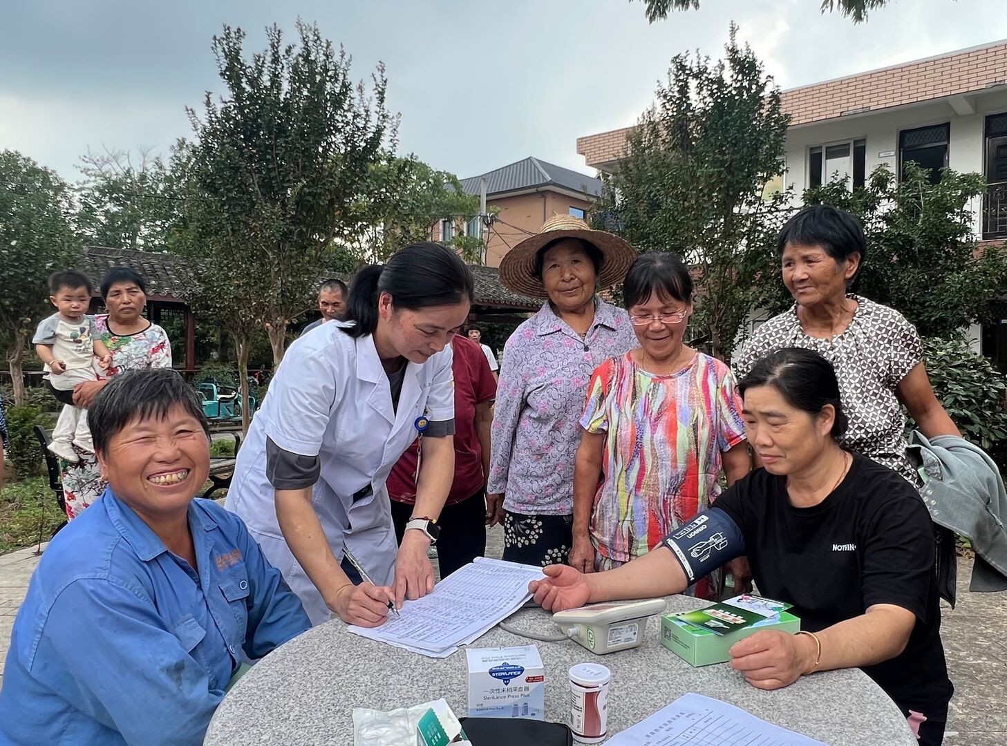 An image depicting health worker visits to residents' home to measure blood pressure as part of a disease screening and follow-up services.